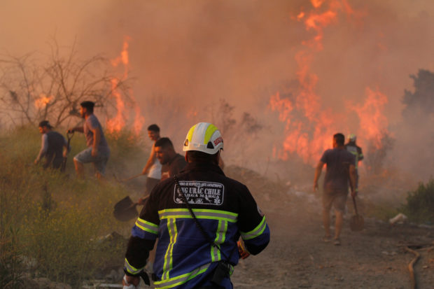 Volunteers work during a wildfire at the 'Santa Rosa de Colmo' area, in Valparaiso