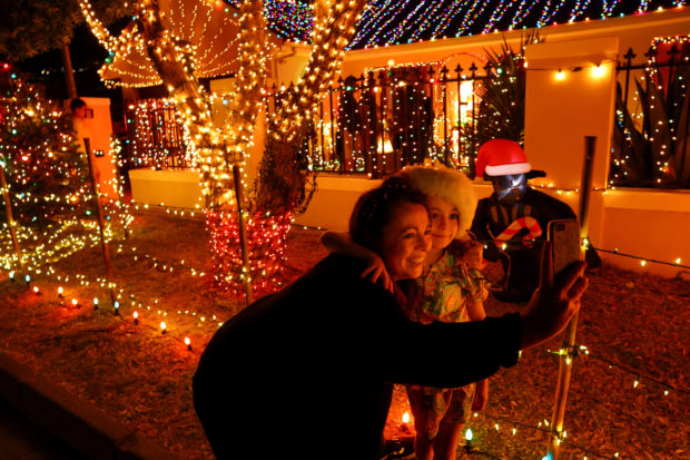 Visitors takes selfies outside the Haines residence in Fish Hoek,