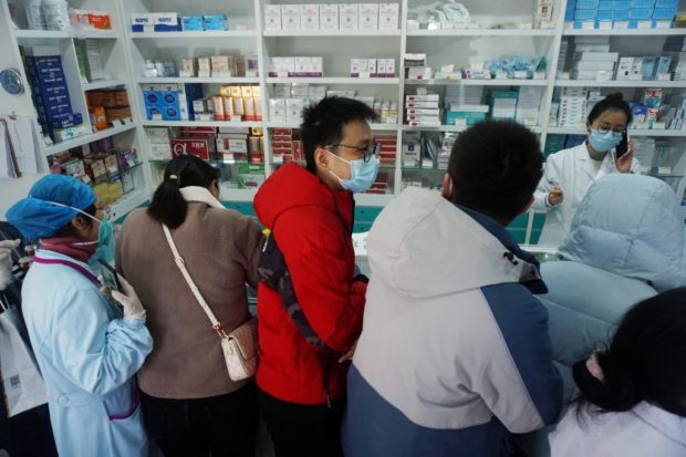 People queue to buy antigen test kits at a pharmacy amid the Covid-19 pandemic in Hangzhou, in China's eastern Zhejiang province on December 19, 2022. (Photo by AFP) / China OUT