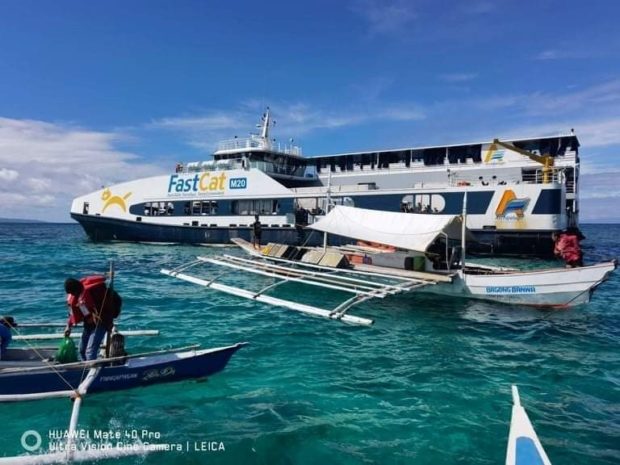 Fishermen help in the rescue operations to transfer passengers and crew members of passenger vessel FastCat to the port after the ship ran aground off the coast of Tubigon, Bohol on Friday, December 23. (Photo courtesy of the Philippine Coast Guard)