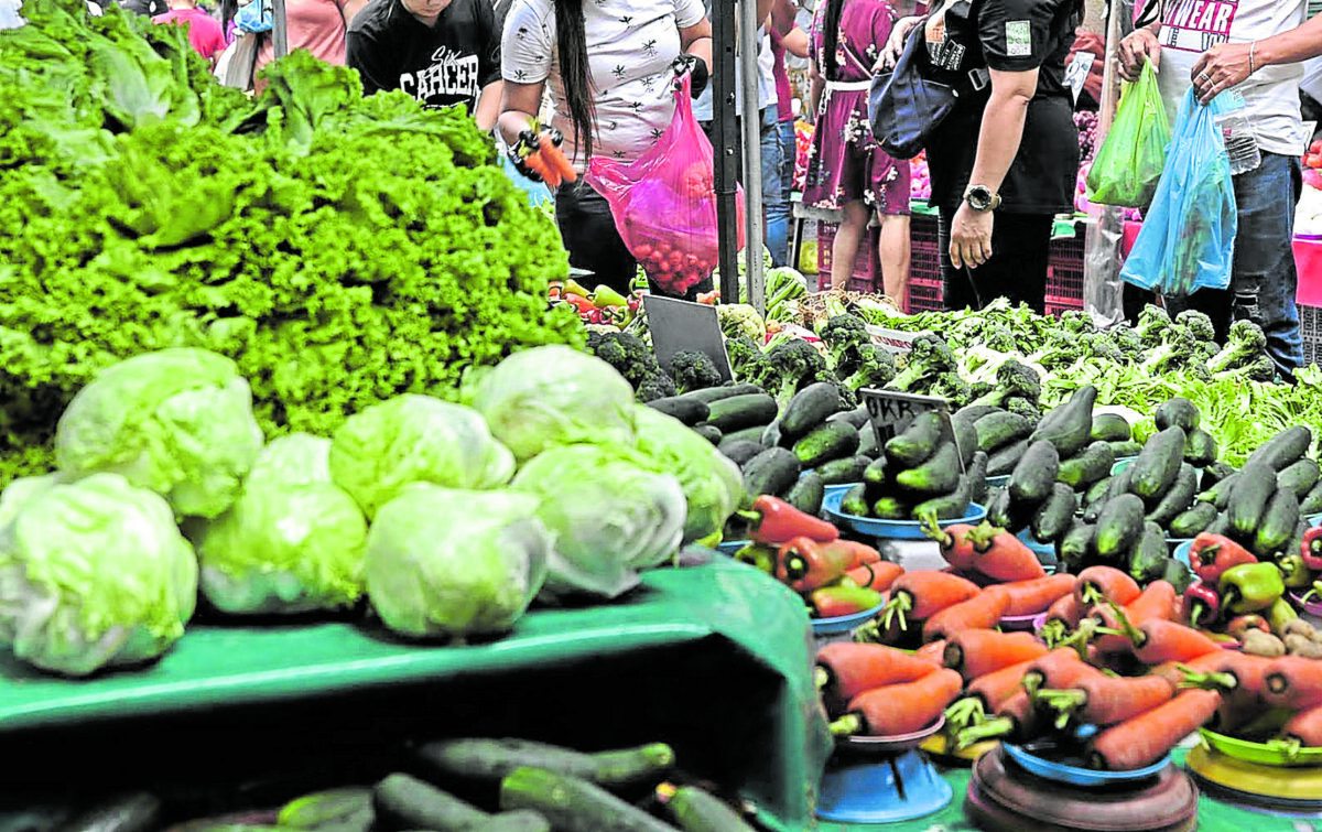 CHRISTMAS AND HIGH PRICES Consumers buy fruits and vegetables at a market in Quiapo, Manila, on Tuesday. These food staples have become more expensive, driving up the country’s inflation. —RICHARD A. REYES
