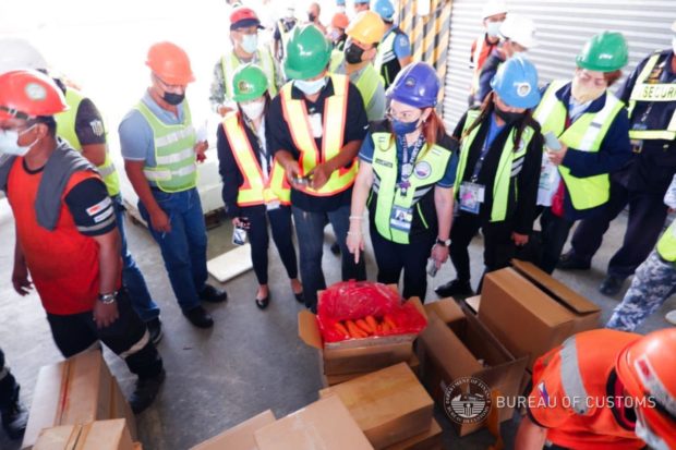 Officials from the Bureau of Customs, Department of Agriculture, Subic Bay Metropolitan Authority and other agencies on Tuesday (Dec. 6) inspect a shipment containing smuggled agricultural products from China. (Photo courtesy of BOC Subic)