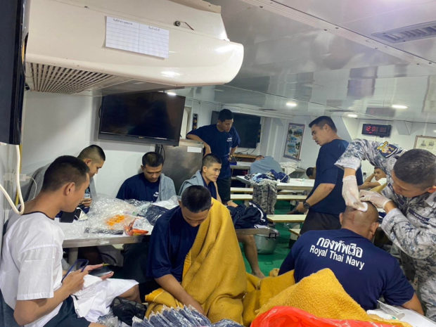 Crew members from the capsized HTMS Sukhothai warship receive medical treatment in the Gulf of Thailand