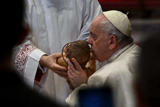 Pope Francis kisses a representation of the baby Jesus Christ as he leads the service marking the World Day of Peace at St Peter's Basilica, in The Vatican on January 1, 2023. - Pope Francis will address the Catholic faithful on January 1, 2023, at the Vatican, the day after the death of his predecessor Benedict XVI at the age of 95. (Photo by Filippo MONTEFORTE / AFP)