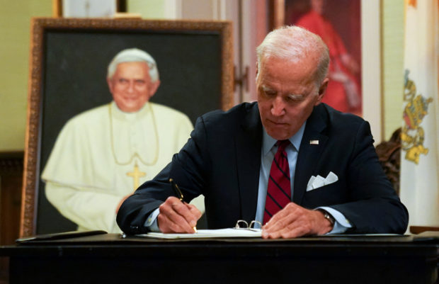 US President Joe Biden signs a condolence book for former Pope Benedict in Washington on January 5.