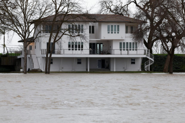 The rain-swollen Sacramento River rises to the foundation level of homes along the river in West Sacramento, California, U.S. January 11, 2023. REUTERS/Fred Greaves