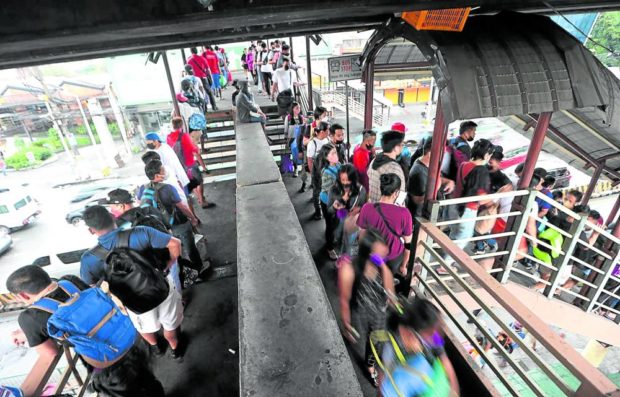 Commuters availing themselves of a bus ride at the Edsa Bus Carousel Station in Cubao, Quezon City, form a long line that stretches to an overpass as many of them return to work on Tuesday, after the New Year holidays. STORY: Paid rides resume, Edsa buses down to 550