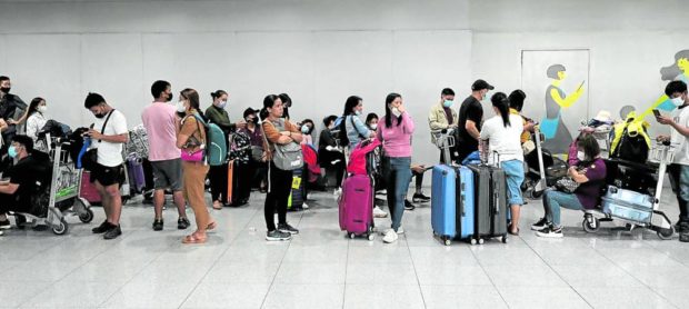 Passengers line up at an airline counter at Ninoy Aquino International Airport Terminal 3, hoping to rebook flights that were canceled due to a power outage that hit the air traffic center on New Year’s Day. STORY: Ople asks labor attaches to help stranded OFWs