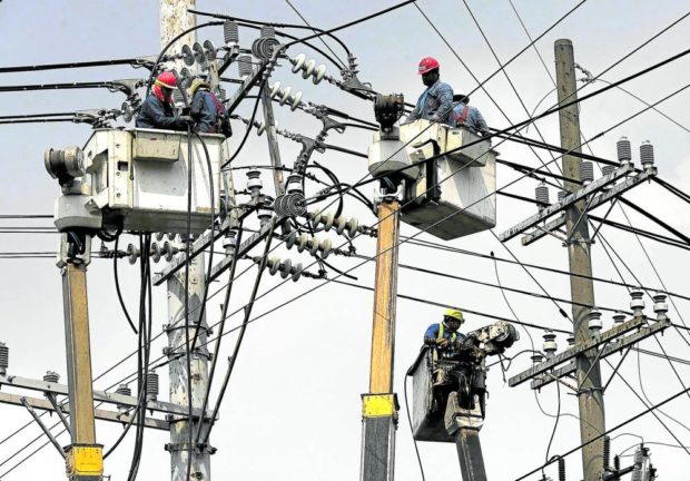 POWER RANGERS Linemen replace cable on electric posts along United Nations Avenue in Manila in this June 2022 photo.  —INQUIRER PHOTO