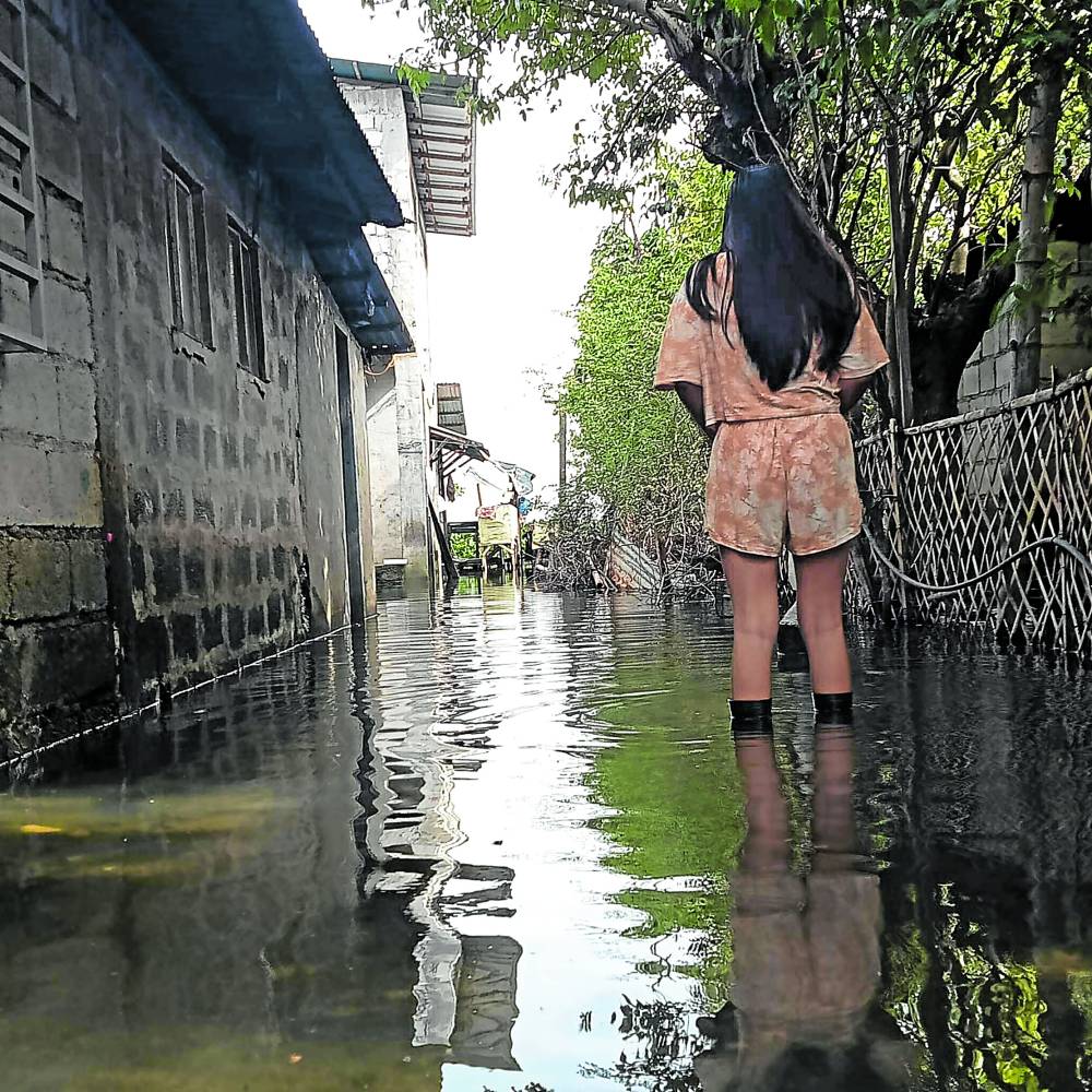 WAITING TO RECEDE A resident of Barangay San Jose in Calumpit town, Bulacan province, wades through floodwater that continues to inundate low-lying areas on Friday, a week after the three dams in the province discharged excess water due to heavy rainfall.