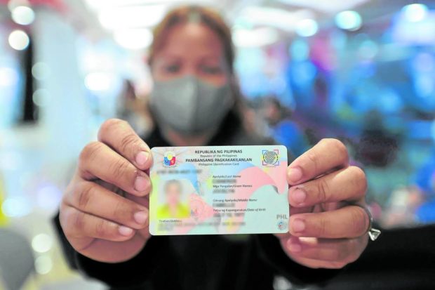 A woman shows her national ID which she got at SM North in Quezon City in July last year.