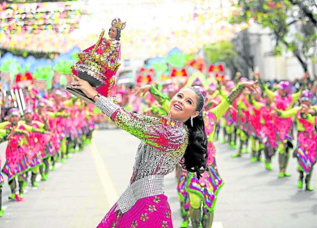 Sinulog dancers perform in the streets of Cebu City during the grand parade before the coronavirus struck the country in March 2020. The rituals in honor of the Seٌor Sto. Niٌo de Cebu is a demonstration of the Cebuanos’ faith. (Photo courtesy of Cebu Daily News)