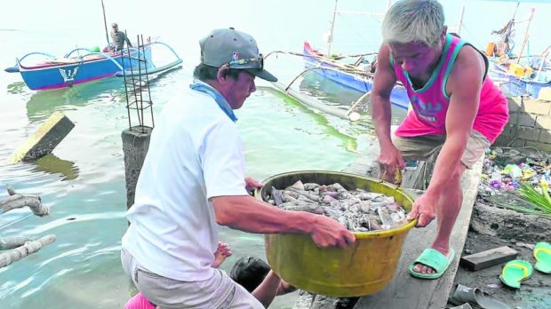 Fishermen in Masinloc town, Zambales, unload a crate of squid caught within the municipal waters.. STORY: Zambales fishers seek damages after HK ship ‘hit’ artificial reefs