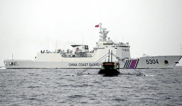 NO EASY PASSAGE  A Chinese Coast Guard ship  stands in the way of a smaller boat manned by members of the Philippine Navy on a resupply mission to  the grounded vessel  BRP Sierra Madre, a Filipino outpost at Ayungin Shoal, in this file photo taken on June 21, 2022. —MARIANNE BERMUDEZ  