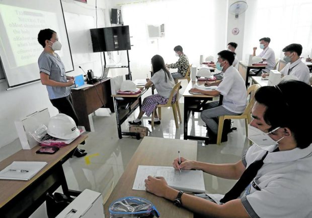 A class of Grade 12 senior high school students at Sen. Renato “Compañero” Cayetano Memorial Science and Technology High School in Taguig City simulate a face-to-face class in general biology led by their teacher Jermaine San Agustin in this Dec. 2. 2021 file photo. 