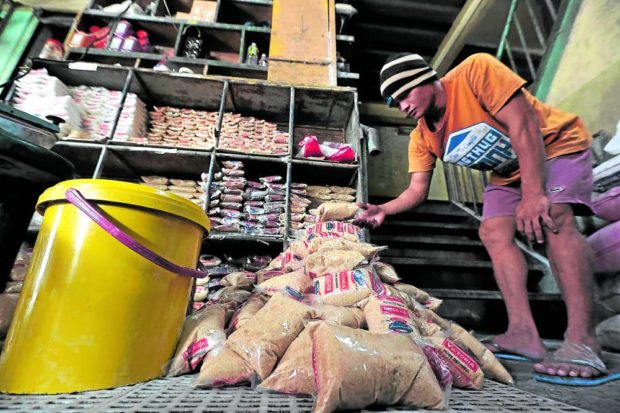 A worker repacks sugar at a Quezon City public market. STORY: Labor groups slam planned importation of 450,000 MT sugar