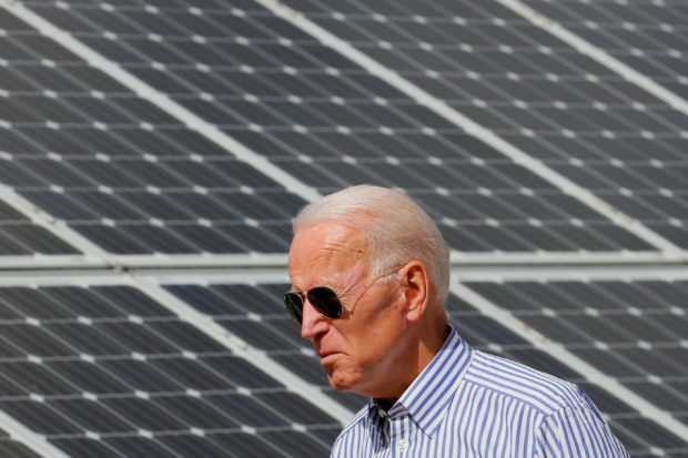 FILE PHOTO: Biden walks past solar panels in Plymouth