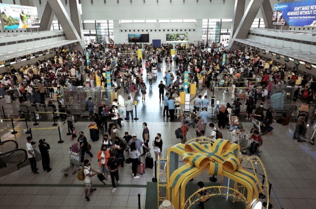 In this photo taken on Jan. 2, 2023 passengers queue at Naia Terminal 3 in Pasay City following the resumption of operations after an equipment breakdown on New Year’s Day. STORY: Senate, House start probe of New Year shutdown at Naia