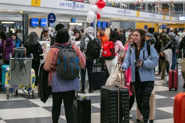 Passengers wait for the resumption of flights at O'Hare International Airport after the Federal Aviation Administration (FAA) had ordered airlines to pause all domestic departures due to a system outage,