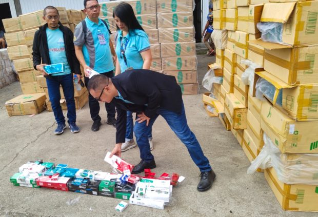 BIR Officials from Davao Region, Digos City, and Police Maritime Command conduct an inventory of the seized cigarettes on Thursday. Photo by Eldie S. Aguirre