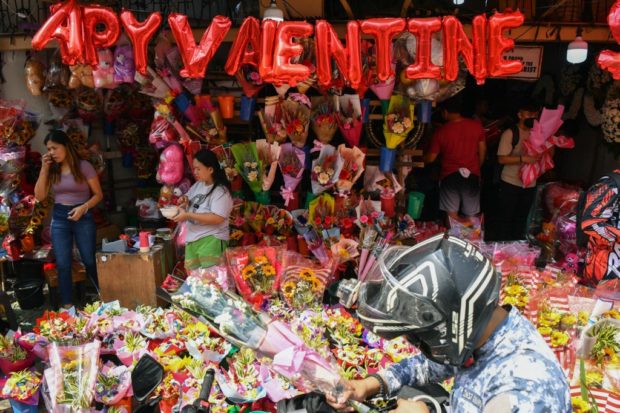 People buy bouquets on Valentine’s Day at a flower market in Manila.