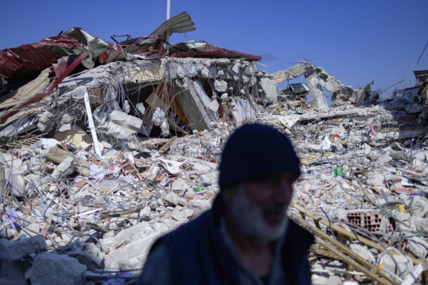 A resident stands in front of his destroyed home in Samandag, south of Hatay on February 16, 2023, ten days after a 7.8-magnitude struck the border region of Turkey and Syria. - Dozens of arms frantically reach for heaters and blankets handed out by a private donor, illustrating the desperation and rage gripping swathes of Turkey 11 days after its disastrous quake. Many in the Syrian border region town of Samandag listened to their relatives and friends slowly die under the rubble as they waited for rescuers who came too late.The United Nations has launched an appeal for USD1 billion to help victims in Turkey of last week's catastrophic earthquake that killed thousands of people and left millions more in desperate need of aid. UN Secretary-General Antonio Guterres said in a statement that the funds would provide humanitarian relief for three months to 5.2 million people. (Photo by Yasin AKGUL / AFP)