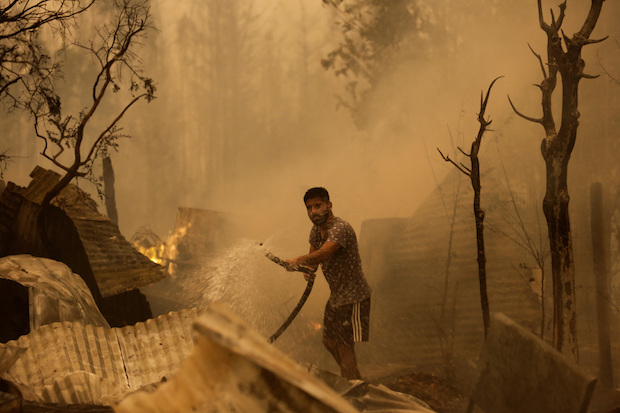 A resident tries to put out a fire in Santa Juan near Concepcion in Chile. STORY: Firefighters battle dozens of wildfires in Chile as emergency extended