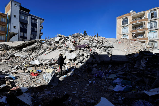 A man searches through the rubble for the remains of his belongings after his apartment was destroyed in the aftermath of a deadly earthquake in Adiyaman, Turkey February 16, 2023. REUTERS/Thaier Al-Sudani