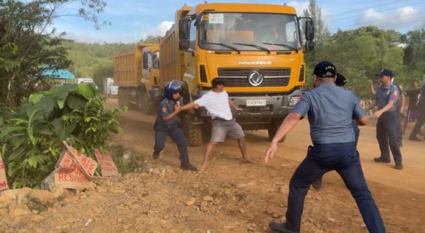 A Sibuyan Island man tries to stop a mining truck from passing. Friday, February 3, 2023. (Photo from Alyansa Tigil Mina)