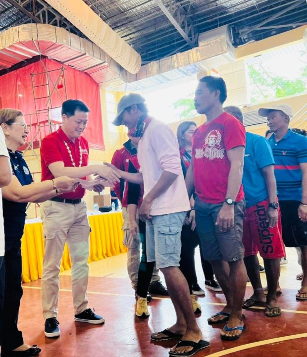 DSWD Secretary Rex Gatchalian helps hand out cash assistance to Typhoon Odette victims on Wednesday, February 8, 2023. 