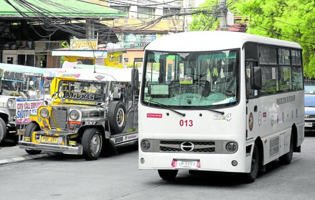 A modern e-jeepney on the road beside an older one. STORY: High amortization, fuel cost pain e-jeepney shifters