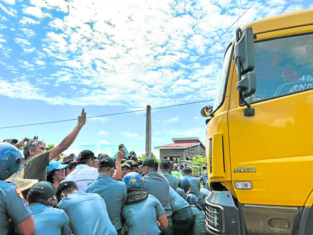 Policemen and antimining groups clash onWednesday as protesters form a human barricade to stop a truck hauling ore from leaving the port of a mining company on Sibuyan Island in San Fernando, Romblon