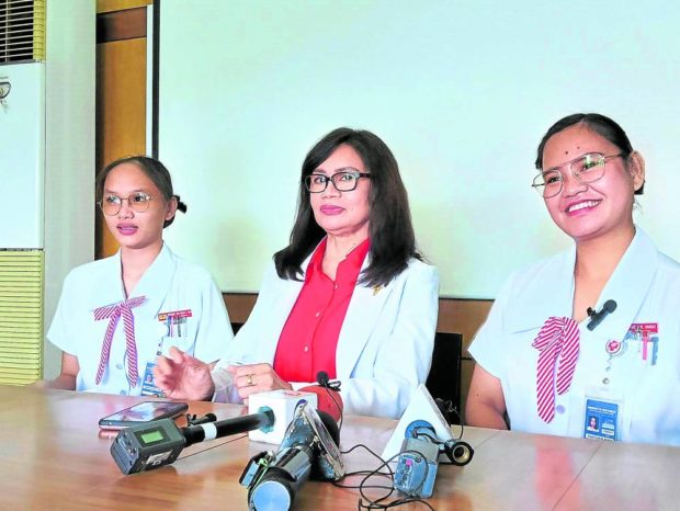 Nursing students Angyl Faith Ababat (right) and Kristianne Joice Noelle Ona (left) are joined by Dean Mercy Milagros Apuhin of the University of Cebu’s College of Nursing in a press conference on Friday. STORY: Nursing student will get scholarship for saving vendor’s life