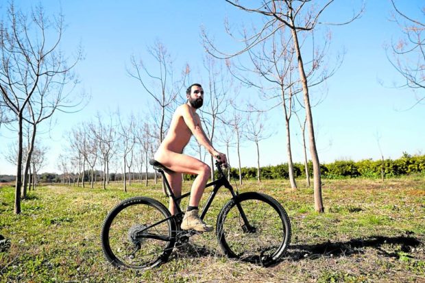A Spanish court has ruled in favor of Alejandro Colomar, shown here riding his bicycle in Aldaia town, near Valencia on Feb. 2, allowing him to continue walking around his village naked as he has been doing since 2020. STORY: Spanish court upholds right to walk naked in streets
