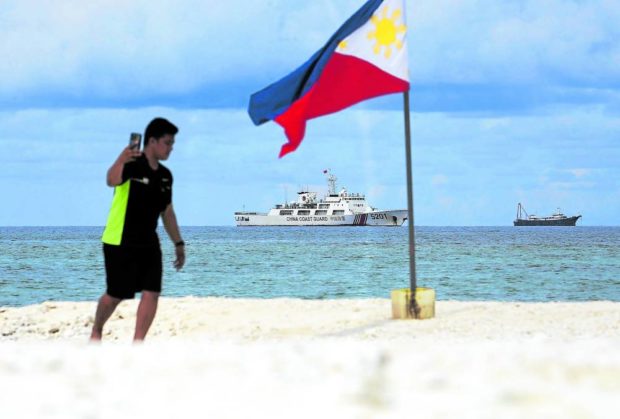 A member of the Philippine Navy, in this June 2022 photo, plants a Philippine flag on Sandy Cay, a sandbar just 7.4 kilometers (4 nautical miles) from Pag-asa Island in the West Philippine Sea where a number of Chinese naval ships have been seen. STORY: Lawmaker wants Pag-asa Island among Edca sites