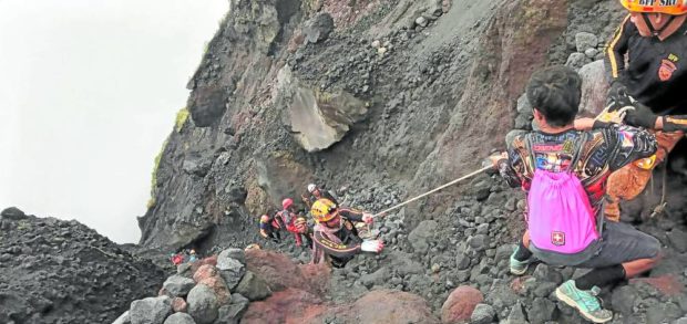 Members of the team tasked to find the Cessna plane that crashed on Mt. Mayon on Feb. 18 make their way toward the wreckage on a gully near the volcano’s summit crater on Thursday