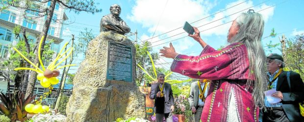 National Artist for Film Kidlat Tahimik takes a photo of a bust dedicated to the late lawyer Damaso Bangaoet Jr.