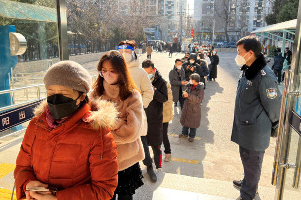 People line up at a government office after China reopened borders, in Beijing