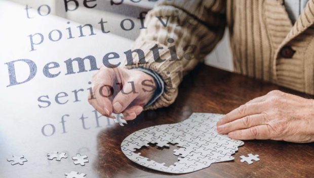 PHOTO: Stck image of senior man’s hand working on a jigsaw puzzle, with the word DEMENTIA superimposed.  STORY: ‘Dementia care policy’ pushed in House