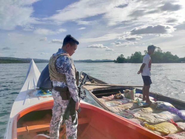 PCG personnel seizes a fishing boat enganged in illegal sand quarrying in the vicinity waters off Barangay Marang-Marang, Malamawi Island, Isabela City, Basilan on Sunday. (Photo from the Philippine Coast Guard)