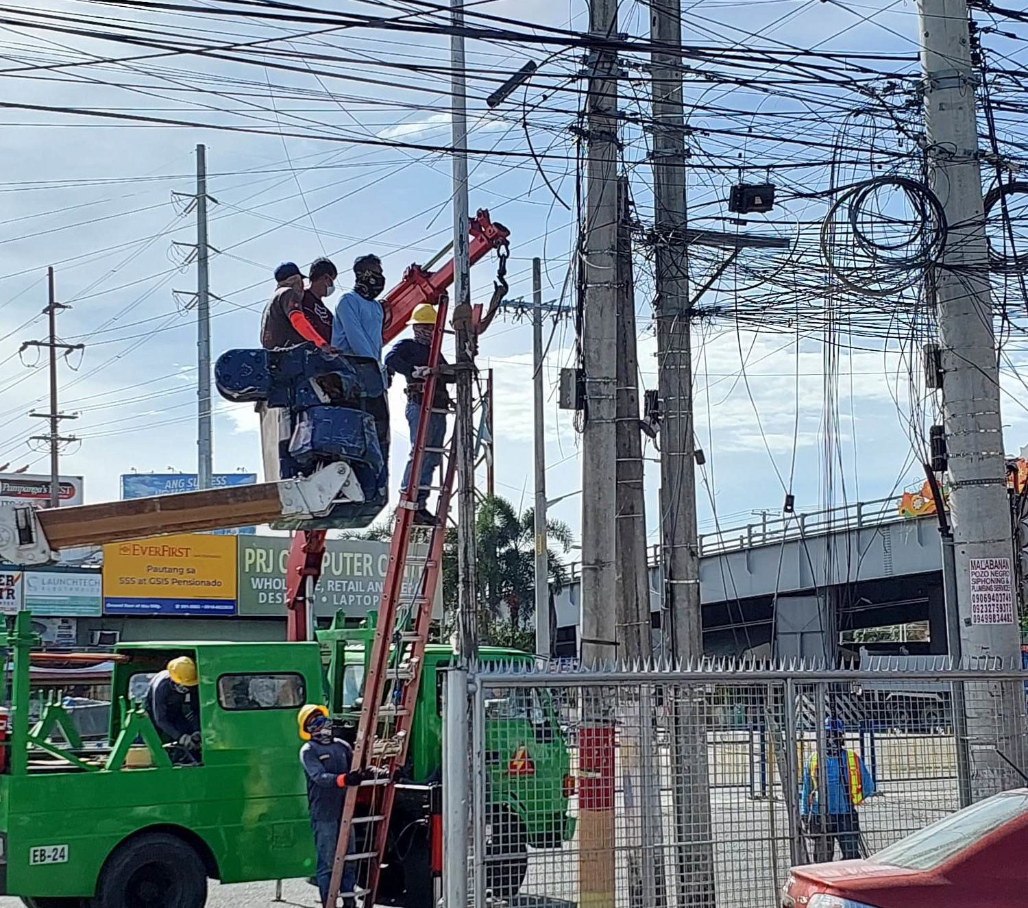 Workers remove the inactive and dangling wires from the San Fernando Electric Light and Power Company's posts.