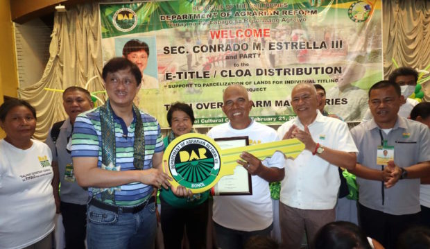 DAR Secretary Conrado Estrella III gives tractor ceremonial key to Angelo Seismundo, President of Cagawasan CARP Farmer Beneficiary Multipurpose Cooperative in Bohol on Tuesday, February 21, 2023. 
