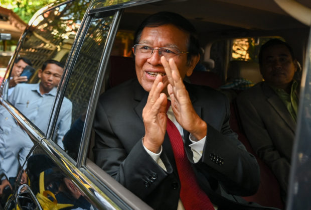Kem Sokha, former leader of the now-dissolved Cambodia National Rescue Party (CNRP), greets the media at his home before going to Phnom Penh Municipal Court for the verdict in his trial in Phnom Penh on March 3, 2023. - A Cambodian court is expected to give a verdict on March 3 in the treason trial of top opposition leader Kem Sokha, in a case critics say is designed to bar him from politics as the country prepares for a July election. (Photo by TANG CHHIN Sothy / AFP)