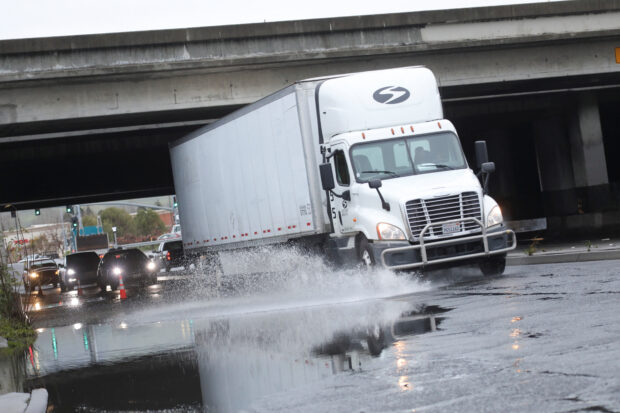 A truck drives through a flooded road after an atmospheric river storm system in Hayward, California, U.S. March 10, 2023. REUTERS/Nathan Frandino