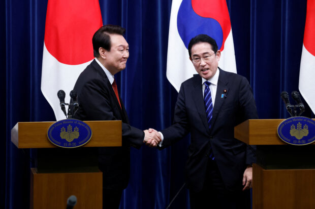 South Korea's President Yoon Suk Yeol and Japan's Prime Minister Fumio Kishida shake hands at a joint news conference at the prime minister's official residence in Tokyo, Japan March 16, 2023. Kiyoshi Ota/Pool via REUTERS