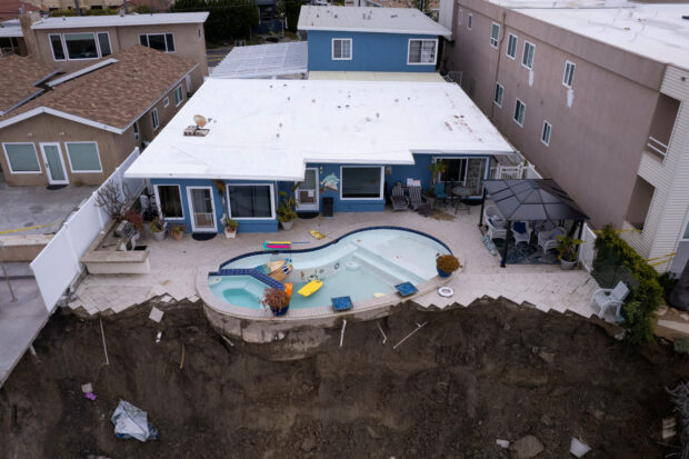 A swimming pool was left dangling partway off the cliff edge as heavy rains soaked into the already sodden ground in California