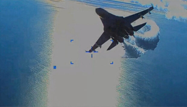 A Russian Su-27 military aircraft dumps fuel while flying by a U.S. Air Force MQ-9 "Reaper" drone over the Black Sea, March 14, 2023 in this still image taken from handout video released by the Pentagon. Courtesy of U.S. European Command/The Pentagon/Handout via REUTERS