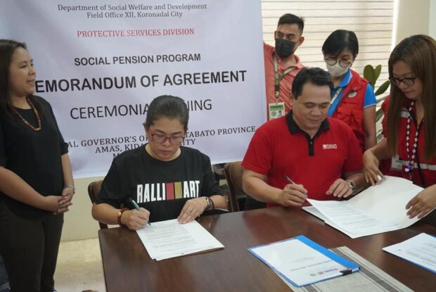 DSWD and local government officials sign a memorandum of agreement.  