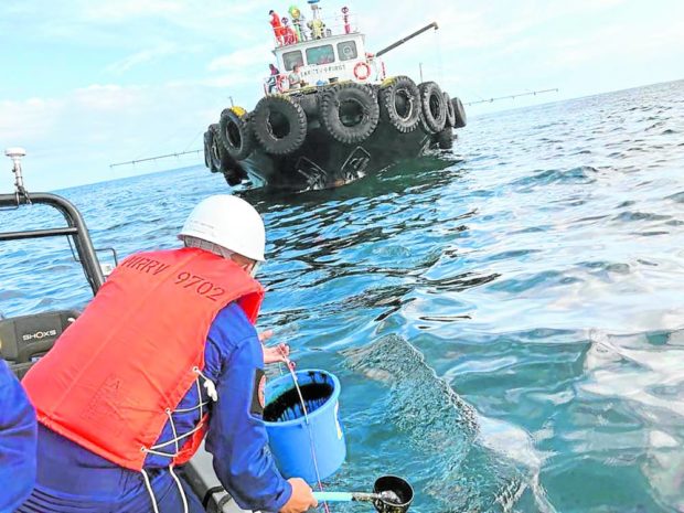 A crew of the Philippine Coast Guard collects water samples from an oil spill in the waters off Naujan, Oriental Mindoro. STORY: Tablas Strait oil spill reaches Antique