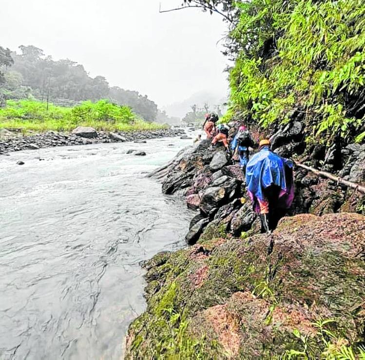 Rescuers cross swollen riversand negotiate slippery and rocky terrain in their search for the crash site of a light aircraft that crashed in Divilacan, Isabela, more than a month ago. 